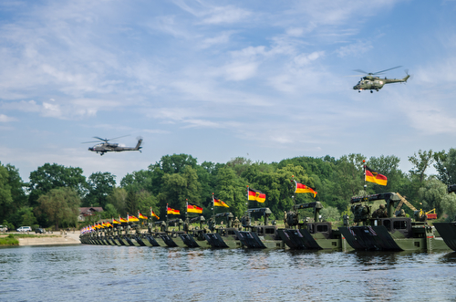 Helicopters fly over troops on a hasty bridge during a bridge crossing operation in Chelmno, Poland, June 8, 2016. Multinational forces coordinated, assembled and then traversed a bridge composed of German and British M3 Amphibious Rigs, allowing vehicles to cross the Vistula River as a part of Exercise Anakonda 2016. The Polish-led exercise is a collective training effort to reinforce interoperability and strengthen bonds between NATO allies and partners, ensuring collective peace and security in the region.